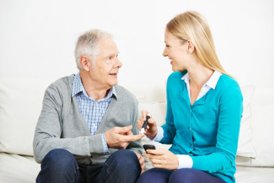 senior man and female caregiver looking at each other