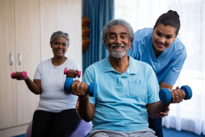 Nurse assisting elderly patients with exercise